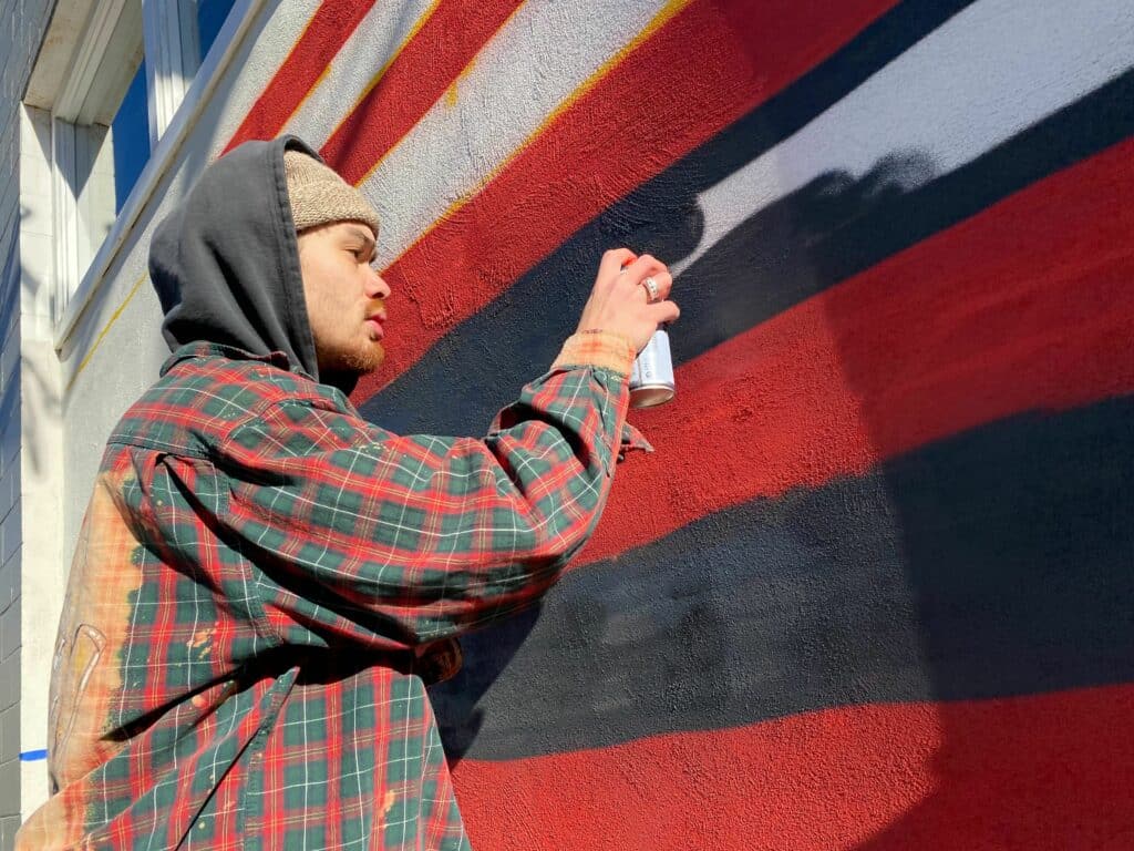 Jordan spray painting the mural.