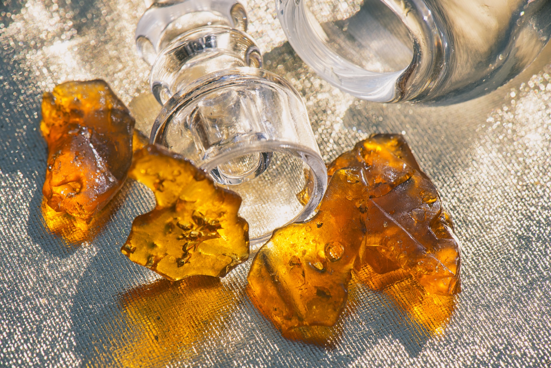 Pieces of cannabis oil concentrate aka shatter with glass rig